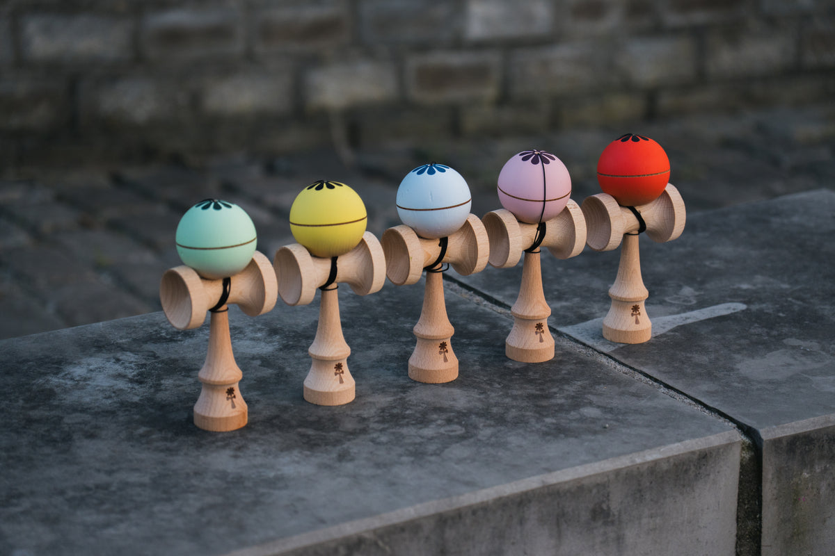 KIN PRIME kendama setups in mint, yellow, light blue, pink and red lined up on concrete
