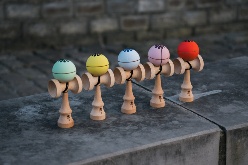 KIN PRIME kendama setups in mint, yellow, light blue, pink and red lined up on concrete